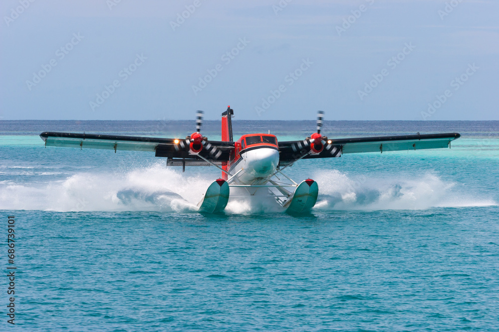 Fototapeta premium Air Taxi Twin Motor Passenger Seaplane Landing in Calm Lagoon Waters of Indian ocean in Republic of Maldives