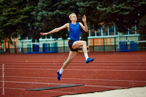 Picture-perfect technique on display as sportsman executes jump. Athletic man, professional sportsman sets new long jump record.