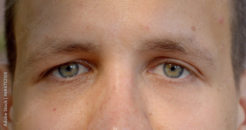 Fototapeta premium Close-up of male eyes blinks, sense of intimacy and connection between viewer and subject, color of the iris. It's as if person is inviting you to look deep into soul. Symbol of identity eyes close up