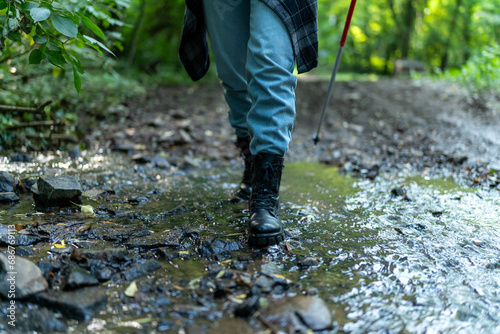 close up image of boots walking through water, hiking concept