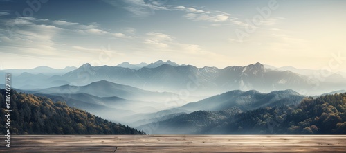 Mountains with fog in a background of a wooden table.