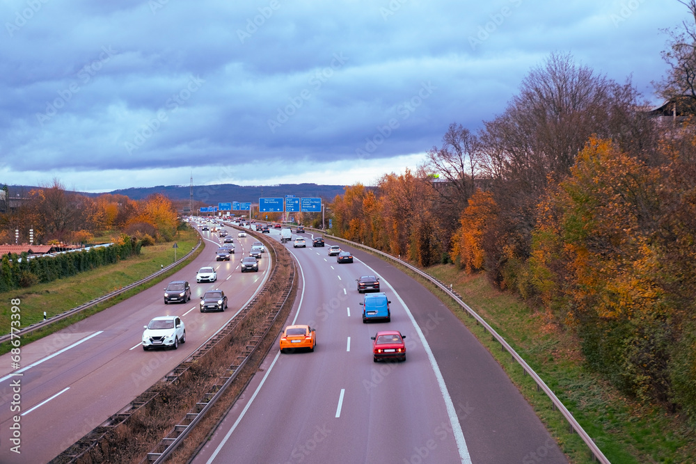 Passenger and freight vehicles travel along A5 autobahn in Germany, with Taunus mountains in background, Transport Network, Safety Traffic on Road, Modern City Living