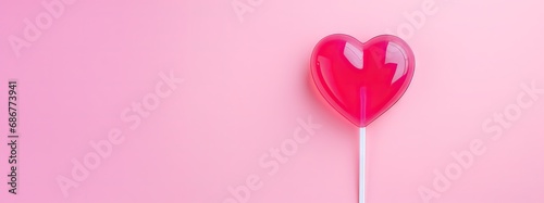 Valentine's day, strawberry lollipop in the shape of a heart on a pink background with copy space photo