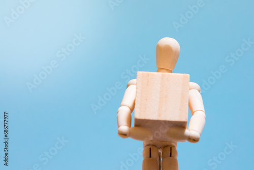 Manual handling at work. Wooden manikin holding a box. Handling technique. Health and safety at work.
