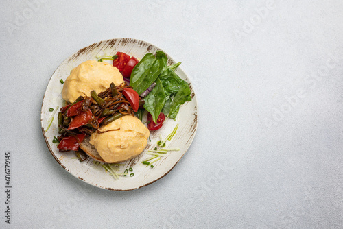 Delicious breakfast - Eggs Benedict with fried vegetables and tomatoes