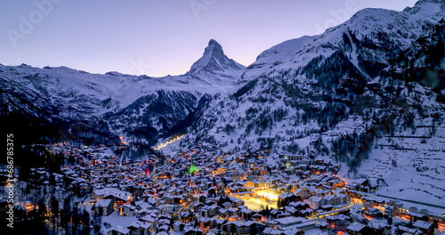 Panoramic landscape of Zermatt city Valley famous travel ski resort and iconic Matterhorn peak at dawn in the swiss alps, Switzerland. The snow covered village and church in Canton Valais in winter. © PixLOG