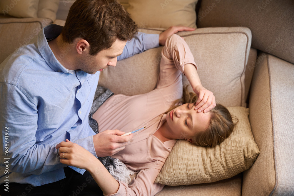 Thoughtful man taking care of his sick young wife Thoughtful man taking care of his sick young wife
