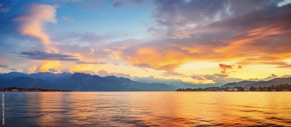 Golden clouds mirror in the water during a vibrant sunset on Lake Geneva in Switzerland Copy space image Place for adding text or design