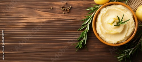 Mashed potato with rosemary and olive oil on wooden table Copy space image Place for adding text or design