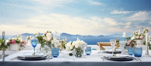 Roof holds flower adorned tables with white cloth porcelain and blue glasses Copy space image Place for adding text or design