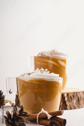 Fototapeta Pumpkin spice latte with whipped cream and cinnamon, warmer autumn and winter ho