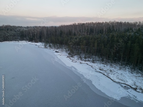 winter forest near a frozen lake 
