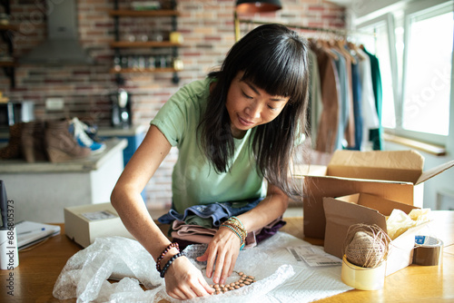 Entrepreneur Woman Preparing Packages for Shipping in Home Office photo