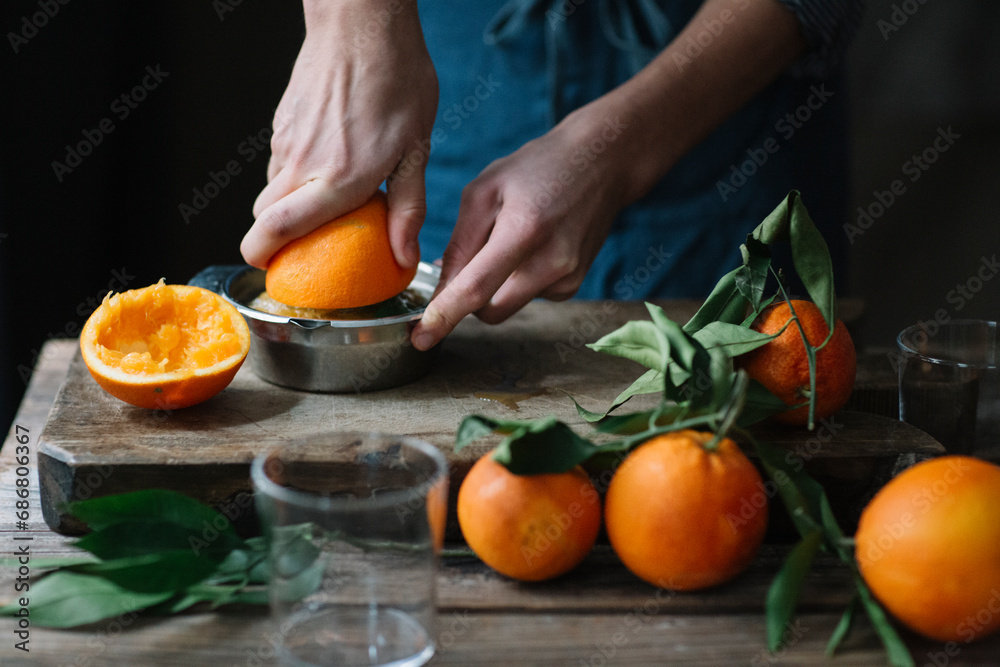 Young man's hands squeezing orange Young man's hands squeezing orange