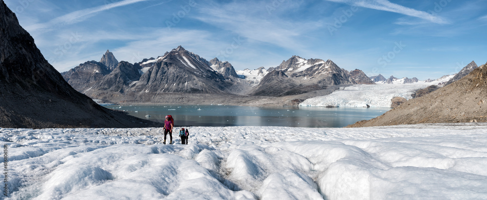 Greenland, Sermersooq, Kulusuk, Schweizerland Alps, group of people walking in snow - obrazy, fototapety, plakaty 