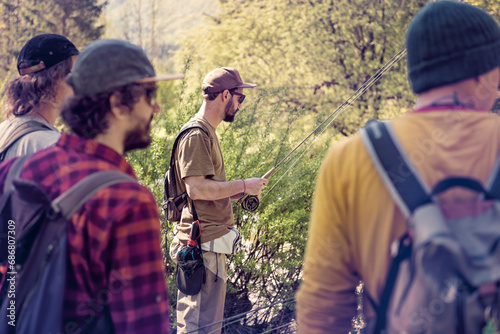 Slovenia, four men preparing for fly fishing in Soca river