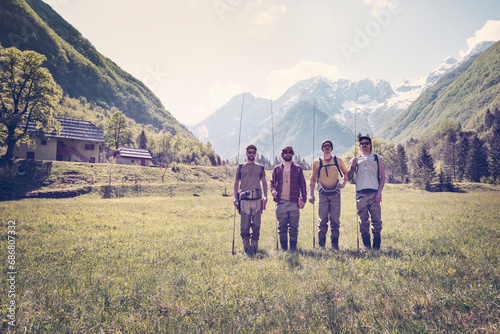 Slovenia, Bovec, four anglers standing on meadow near Soca river photo