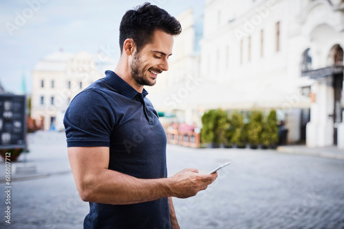 Smiling man using cell phone in the city photo