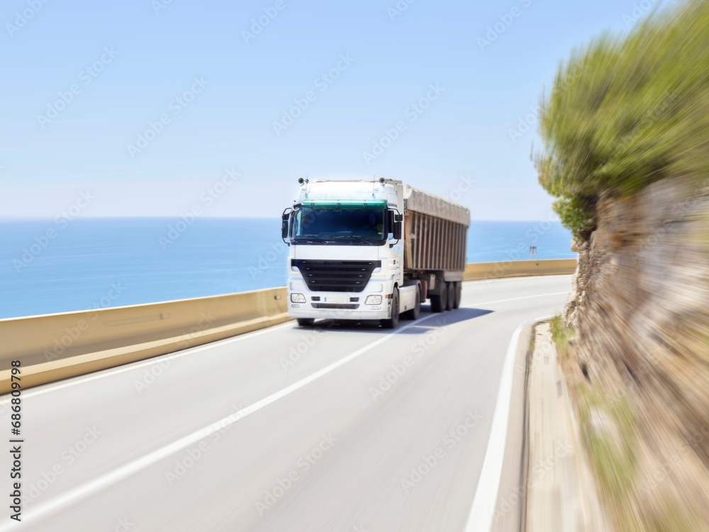 Truck driving alongJersey barrierof coastal highway, Sitges, Barcelona, Spain
