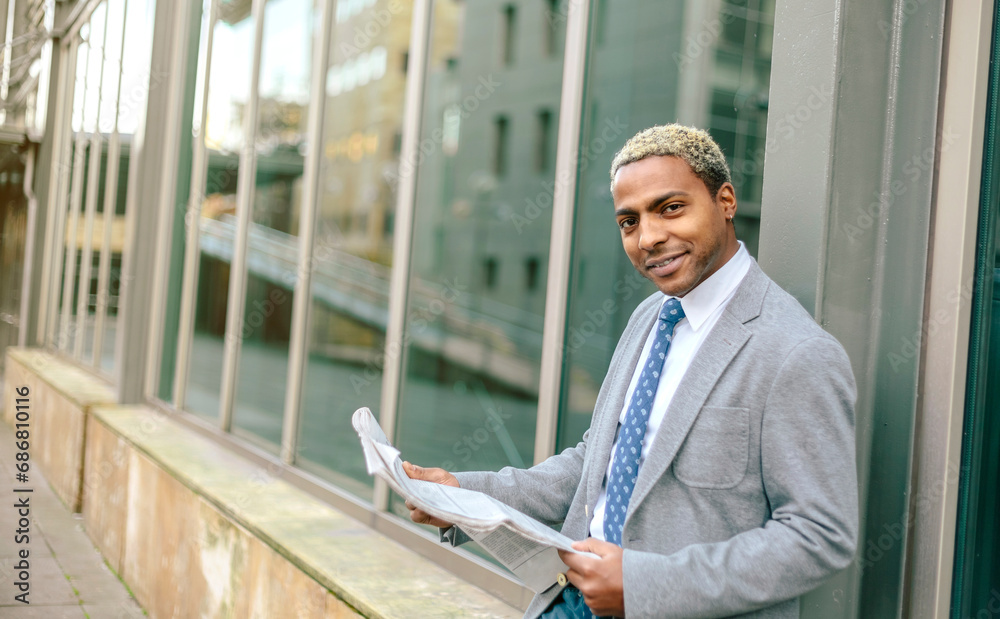 Businessman leaning against wall, reading newspaper Businessman leaning against wall, reading newspaper