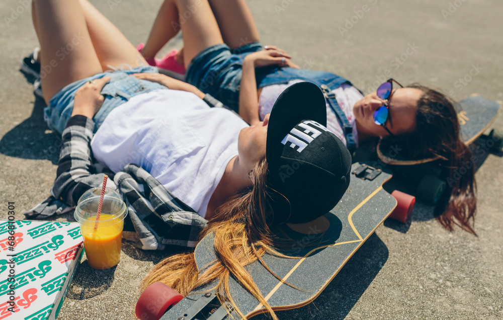 Two young women with longboards enjoying summer Two young women with longboards enjoying summer