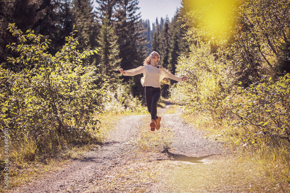 Girl running and jumping on a forest path, having fun Girl running and jumping on a forest path, having fun