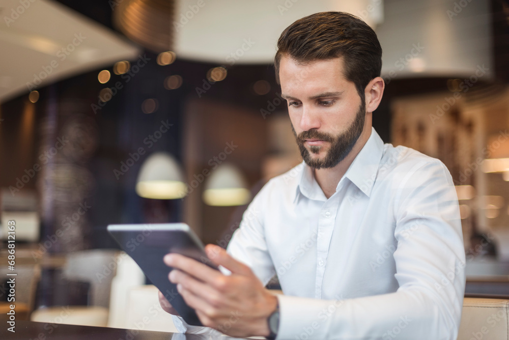 Young businessman using tablet in a cafe Young businessman using tablet in a cafe