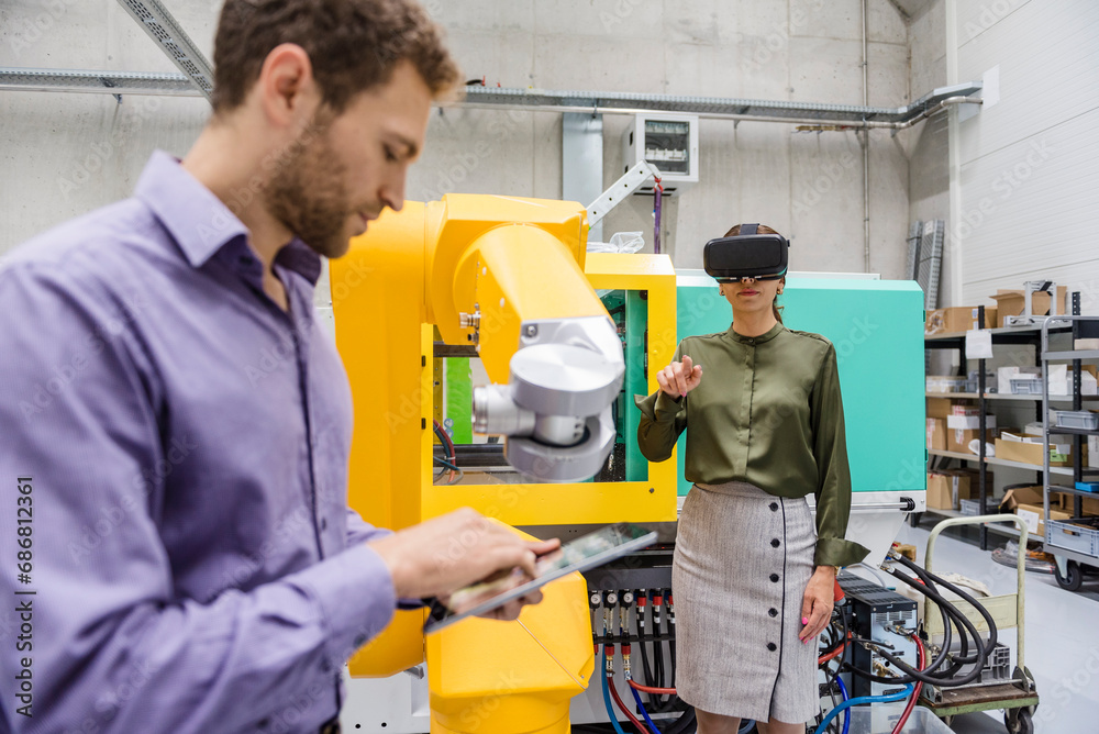 Colleagues in high tech company testing new technologies, using digital tablet and VR goggles Colleagues in high tech company testing new technologies, using digital tablet and VR goggles