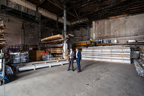 Two businessmen with folder talking in an old storehouse © tunedin