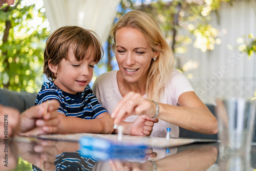 Mother and son playing a board game on terrace