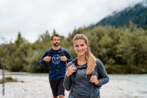 Young couple on a hiking trip at riverside, Vorderriss, Bavaria, Germany