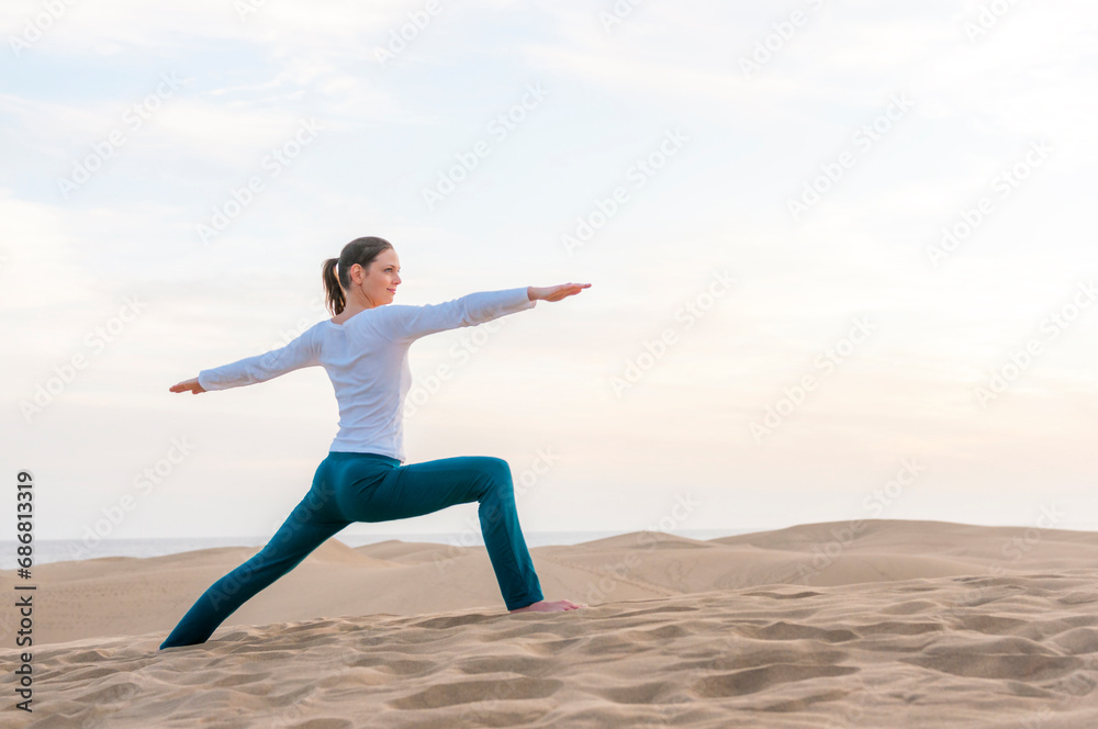 Woman practicing yoga at sunset in the dunes, Gran Canaria, Spain Woman practicing yoga at sunset in the dunes, Gran Canaria, Spain