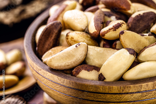 bowl with peeled Brazil nuts on a rustic table. healthy cooking ingredient photo