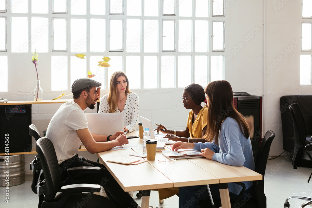 Colleagues working together at desk in office