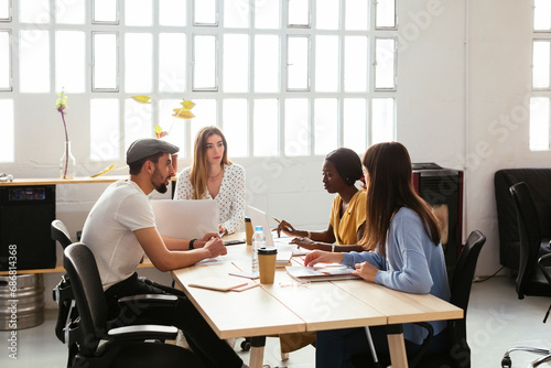 Colleagues working together at desk in office