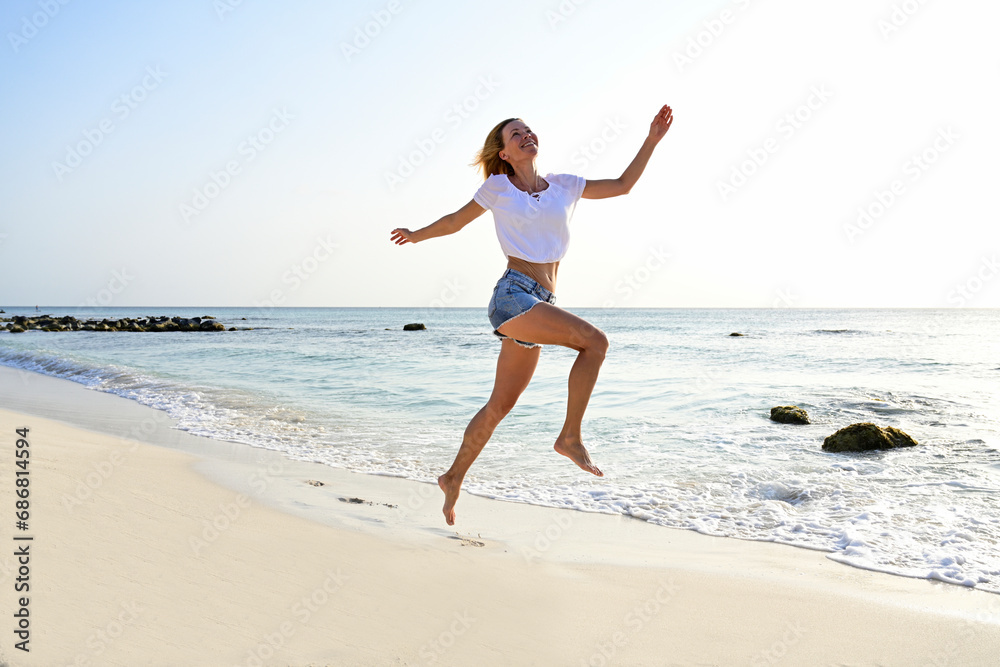 Beautiful woman running and jumping for joy on the beach Beautiful woman running and jumping for joy on the beach