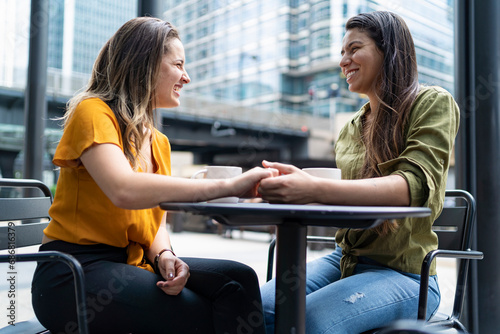 Happy lesbian couple at a sidewalk cafe in the city, London, UK