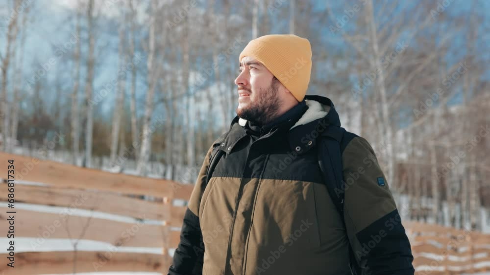 Step into the bliss of winter hiking with a Caucasian man explorer, walking, showcasing the exhilaration and beauty of a snowy trek in slow motion.