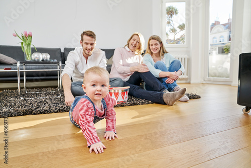 Happy familiy with baby girl in living room photo