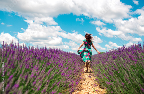 France  Provence  Valensole plateau  back view of woman running among lavender fields in summer