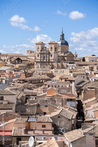Vertical image of the rooftops of the historic center of Toledo, Spain with the Jesuit Church of San Ildefonso towering above the houses in the center of the image