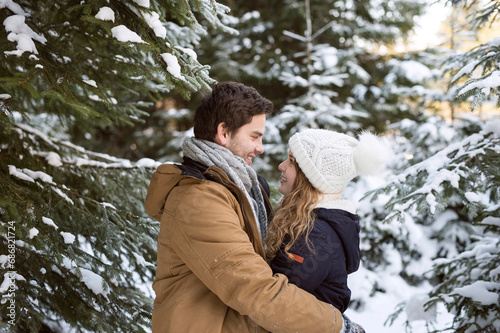 Happy young couple face to face in snow-covered winter forest © tunedin