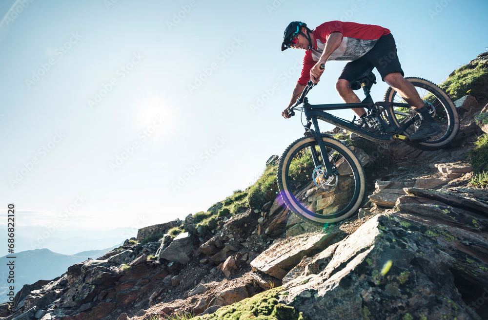 Mountainbiker mountain biking against the sun in Grisons, Switzerland