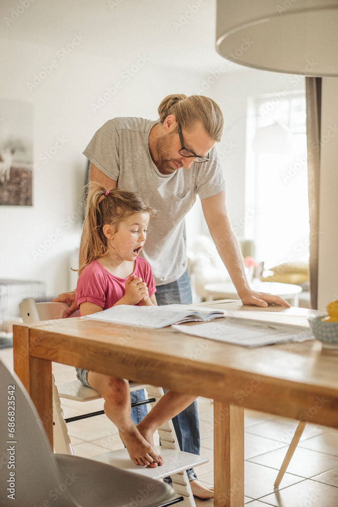 Father checking homework of his daughter Father checking homework of his daughter