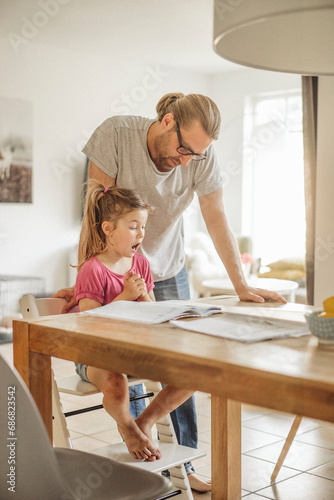 Father checking homework of his daughter