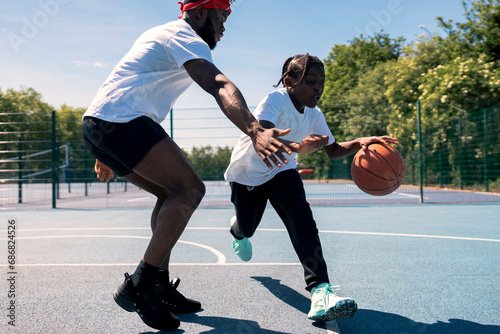 Father and son playing basketball on basketball court photo