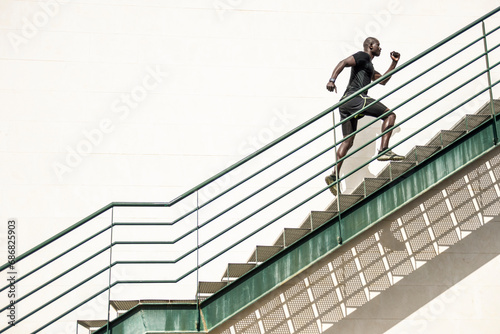 Man in black sportswear running up staircase © tunedin