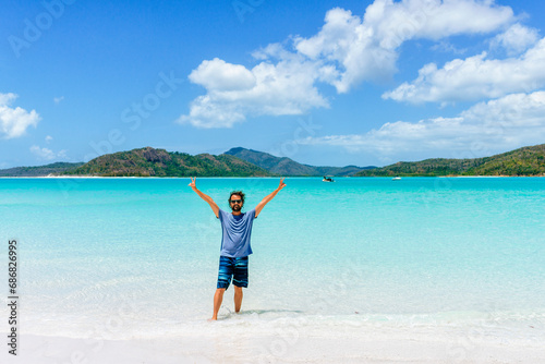 Australia, Queensland, Whitsunday Island, man with raised arms standing at Whitehaven Beach photo