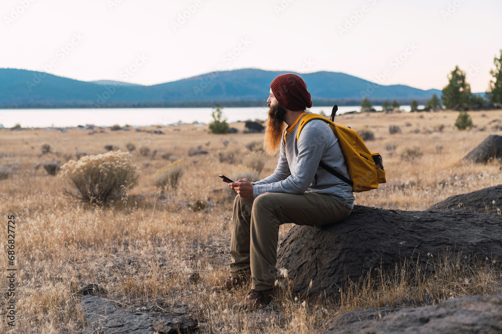 USA, North California, bearded young man having a break on a hiking trip near Lassen Volcanic National Park