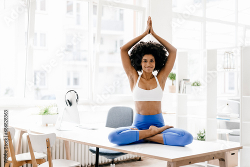 Young woman practising yoga on her desk
